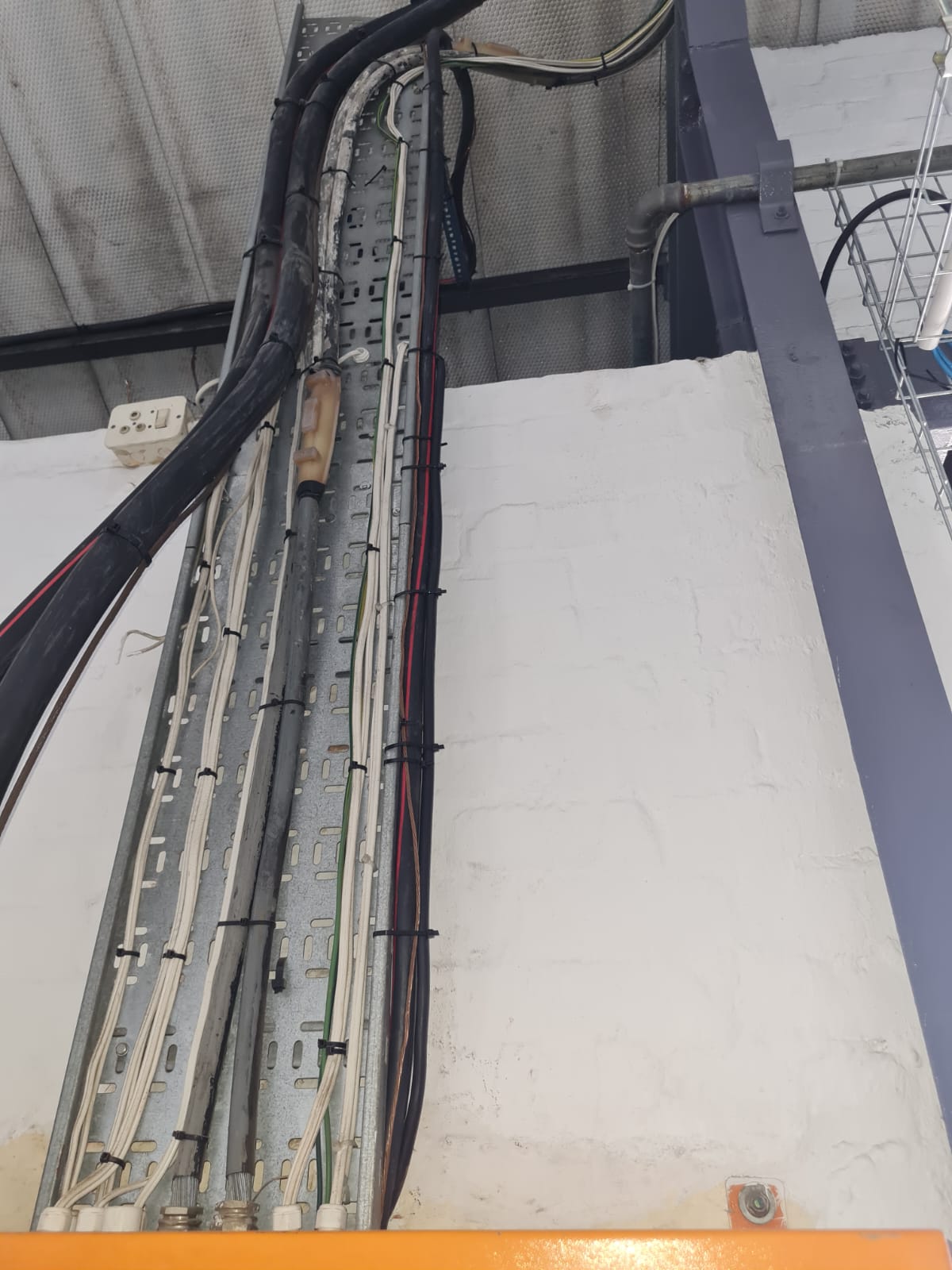 Neatly bundled cables running along cable tray in the packing facility